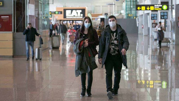 personas con cubrebocas en el aeropuerto