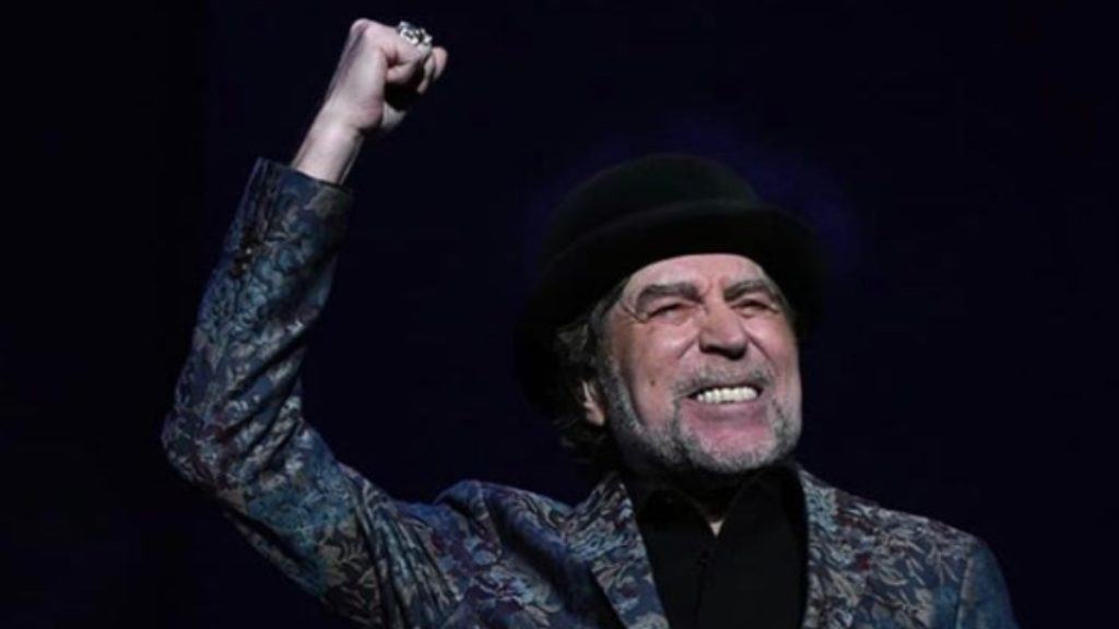 El cantautor español Joaquín Sabina cierra el puño y frunce el ceño durante un concierto.