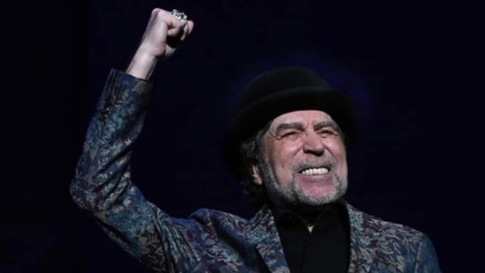 El cantautor español Joaquín Sabina cierra el puño y frunce el ceño durante un concierto.